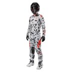 Piloto de motocross con el Alpinestars 2024 Techstar Rantera Jersey en Haze Gray Camo, pantalones a juego con detalles rojos y negros, casco y gafas negras, guantes negros y botas blancas y negras, equipamiento completo de motocross para rendimiento off-road