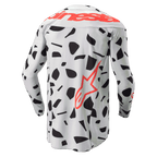 Alpinestars 2024 Techstar Rantera Jersey, vista posterior, jersey de motocross de manga larga, Camuflaje Gris Haze con patrones abstractos negros, con la marca Alpinestars en rojo sobre los hombros y un logotipo de estrella roja en el lateral inferior, diseñado para el rendimiento todoterreno