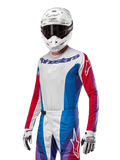 Alpinestars Techstar Pneuma Jersey 2024, jersey de motocross, azul Mars, rojo y blanco con acentos morados, ajuste atlético de carrera, equipamiento de alto rendimiento de manga larga usado con casco y guantes blancos