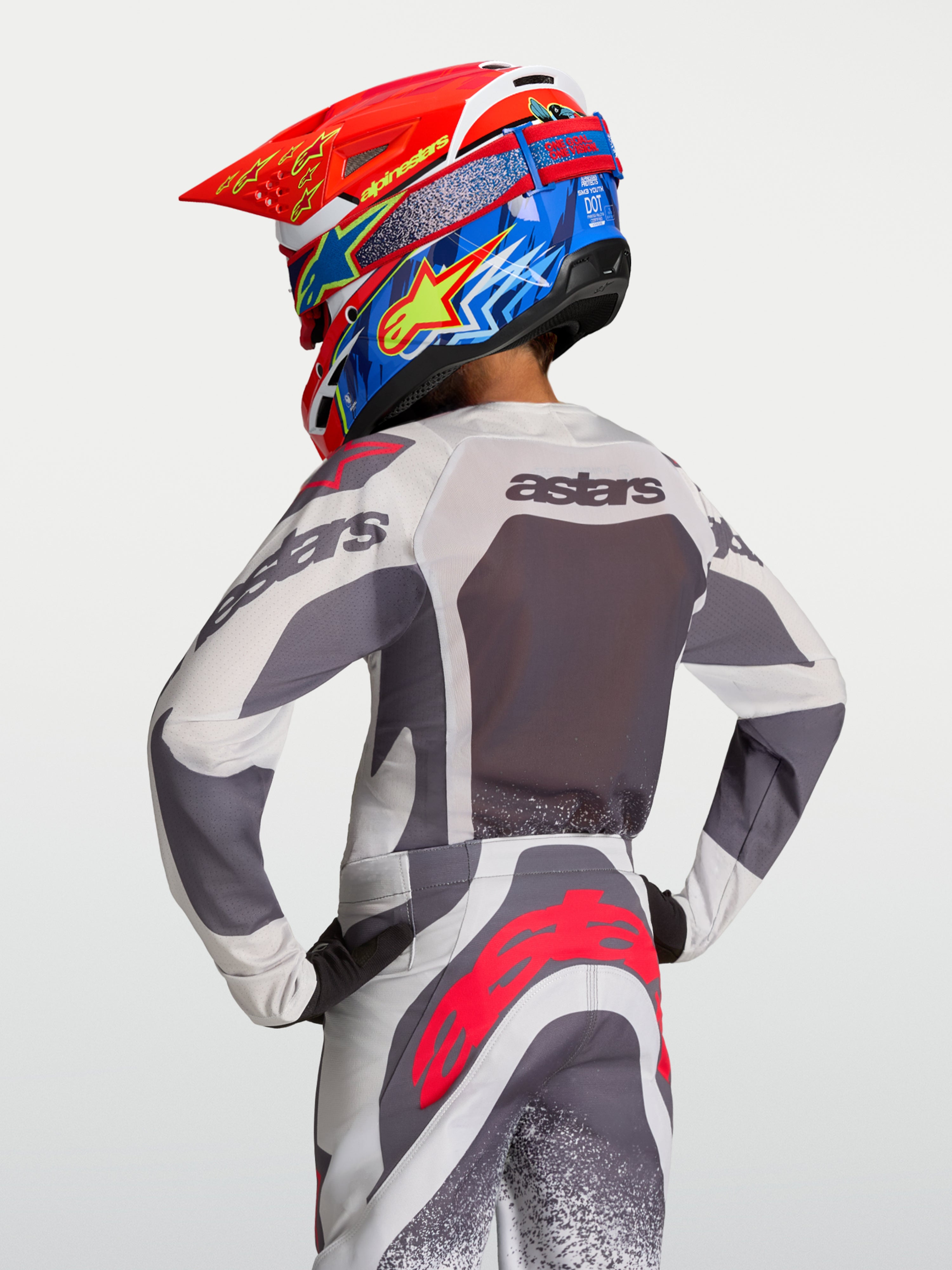 Jersey Alpinestars Supertech Swan juvenil 2027, de motocross en malla transpirable gris y lila, vista trasera del piloto.