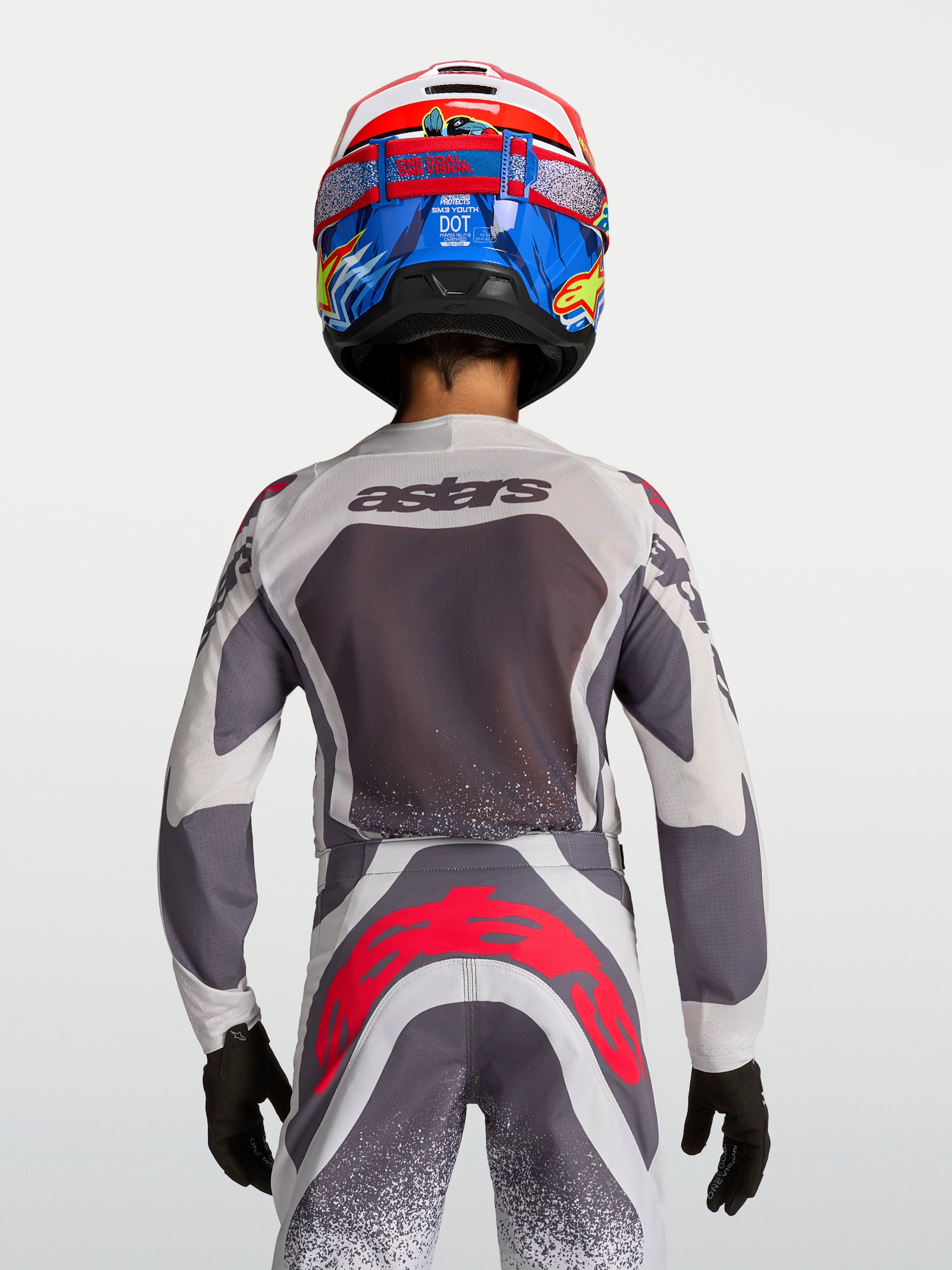 Jersey y pantalones Alpinestars Supertech Swan Juvenil, equipo de motocross gris y blanco con rojo flúor, vista trasera