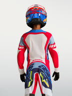 Jersey Alpinestars Supertech Dyna juvenil 2027 de motocross, rojo y azul marino, malla elástica, vista trasera en piloto.