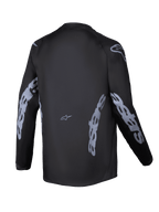 Alpinestars 2025 Youth Racer Graphite Jersey, vista posterior, negro y gris, jersey de motocross de manga larga con la marca Alpinestars en gris en las mangas y los laterales, tejido que absorbe la humedad con un corte trasero más largo para la conducción off-road