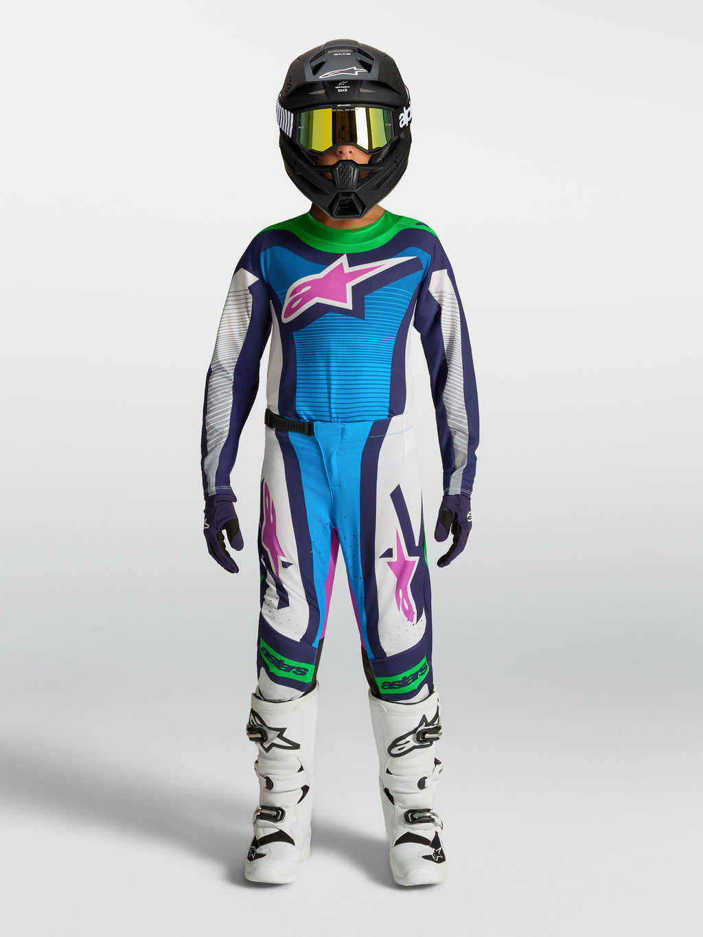 Alpinestars Supertech Maven Gear Set juvenil, conjunto de motocross azul y blanco con detalles verdes y rosa, en modelo.