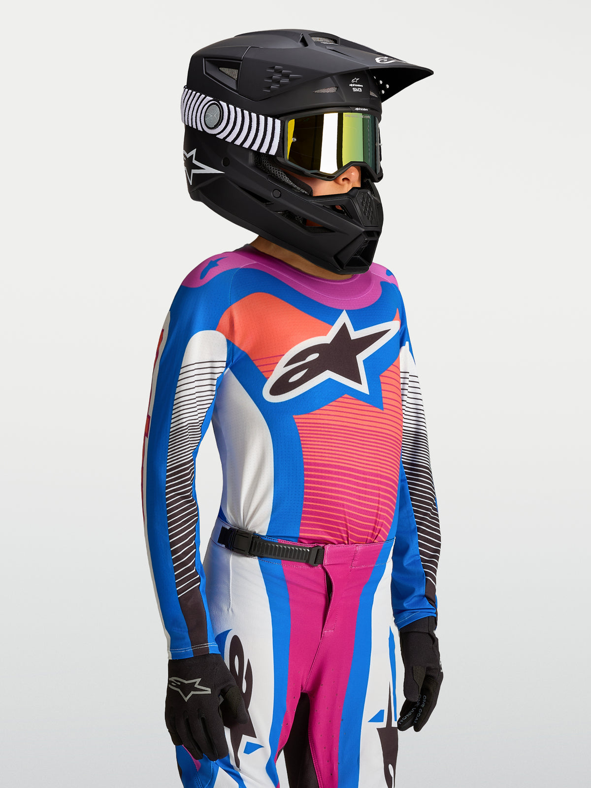 Alpinestars Jersey Supertech Maven Juvenil, equipo de motocross transpirable azul y coral para jóvenes con casco negro.