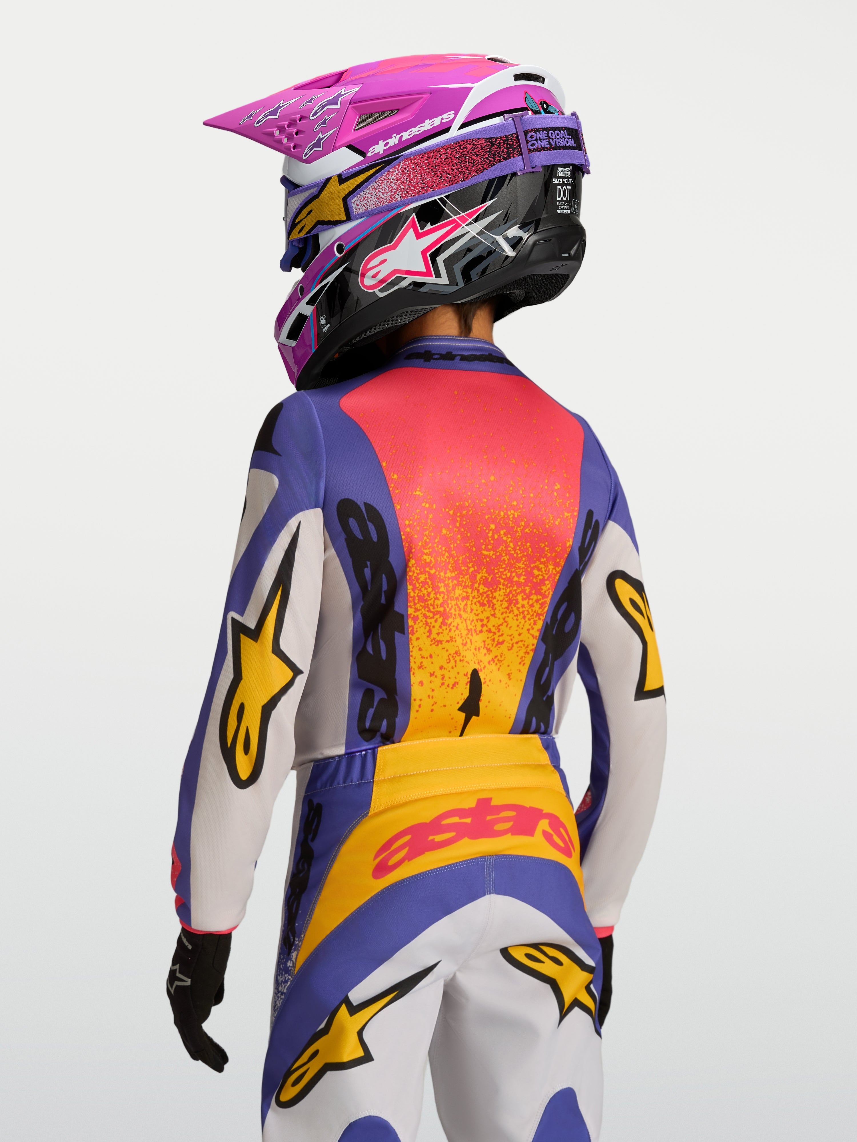Alpinestars Jersey Fluid Drag Juvenil 2027, jersey de motocross morado y naranja, tejido transpirable, vista trasera en modelo