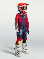 Alpinestars 2027 Youth Fluid Drag Gear Set, kit de carreras de motocross juvenil azul marino y rojo fuego con botas blancas.
