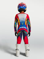Jersey Alpinestars Fluid Drag juvenil y conjunto de motocross, azul marino y rojo fuego, vista trasera en piloto.
