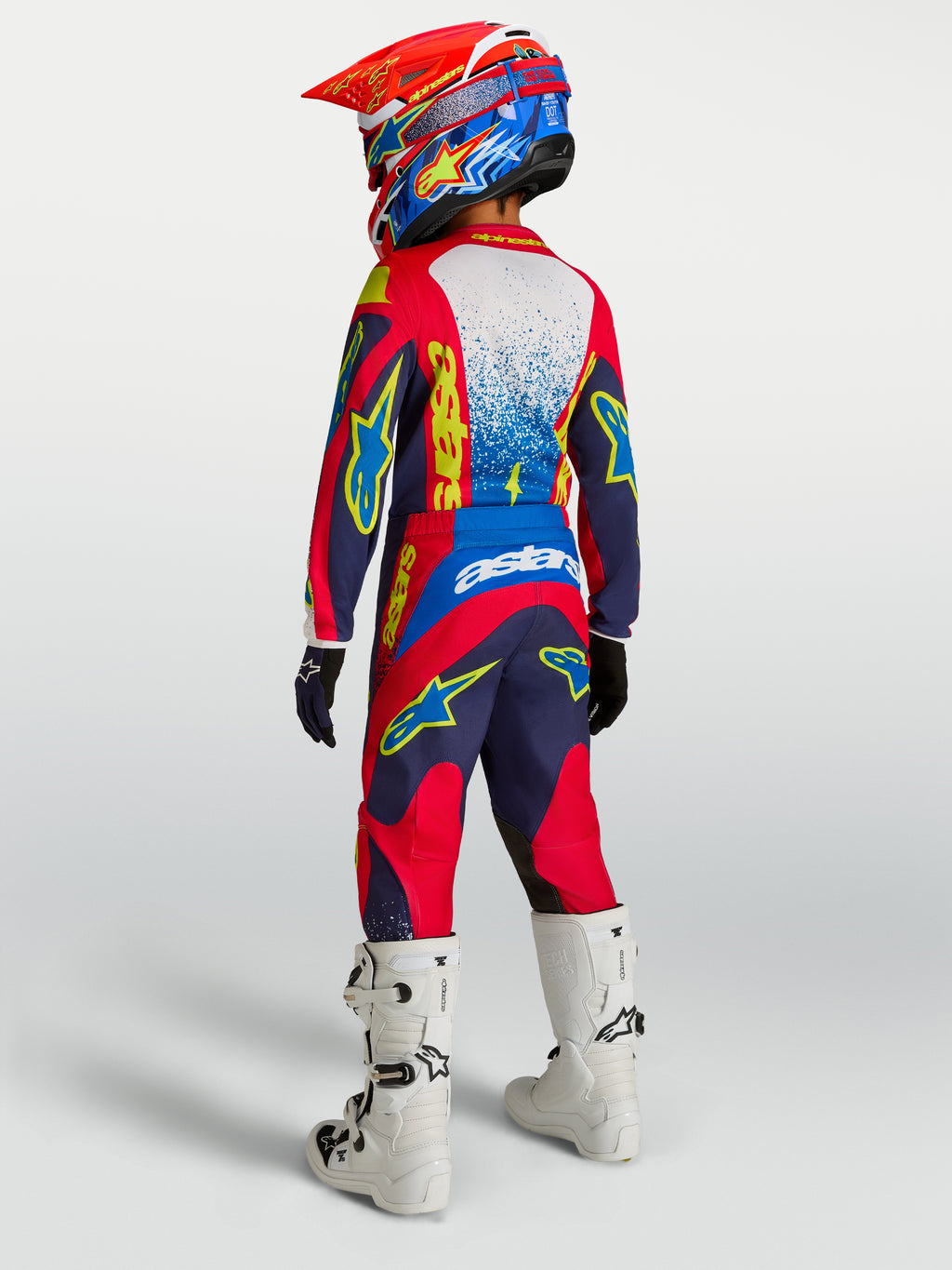 Alpinestars Fluid Drag juvenil 2027, conjunto de motocross, azul marino y rojo fuego, vista trasera con botas blancas