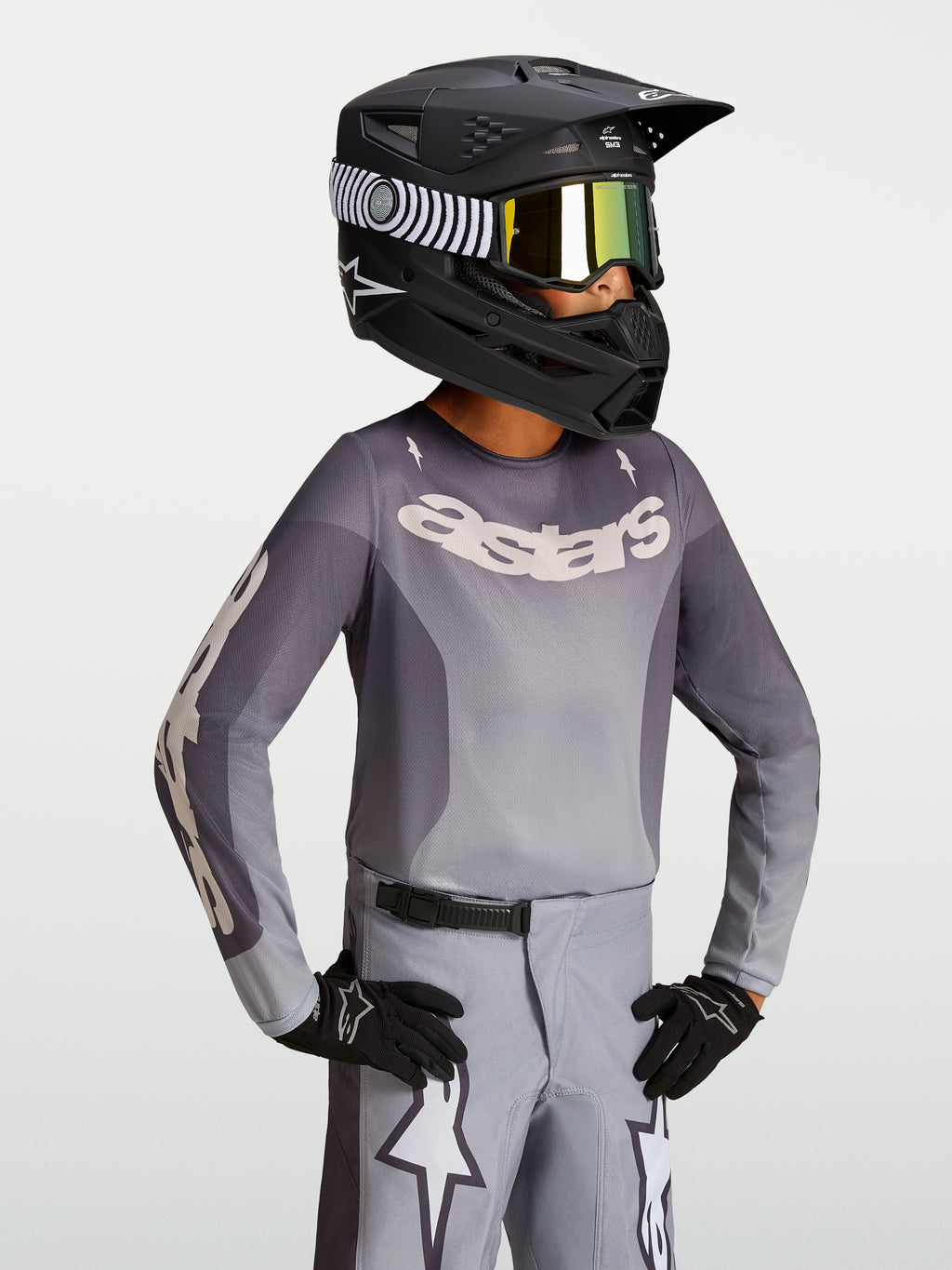 Alpinestars Jersey Fluid Amber Juvenil 2027, jersey de motocross, arena y gris, modelo con casco negro