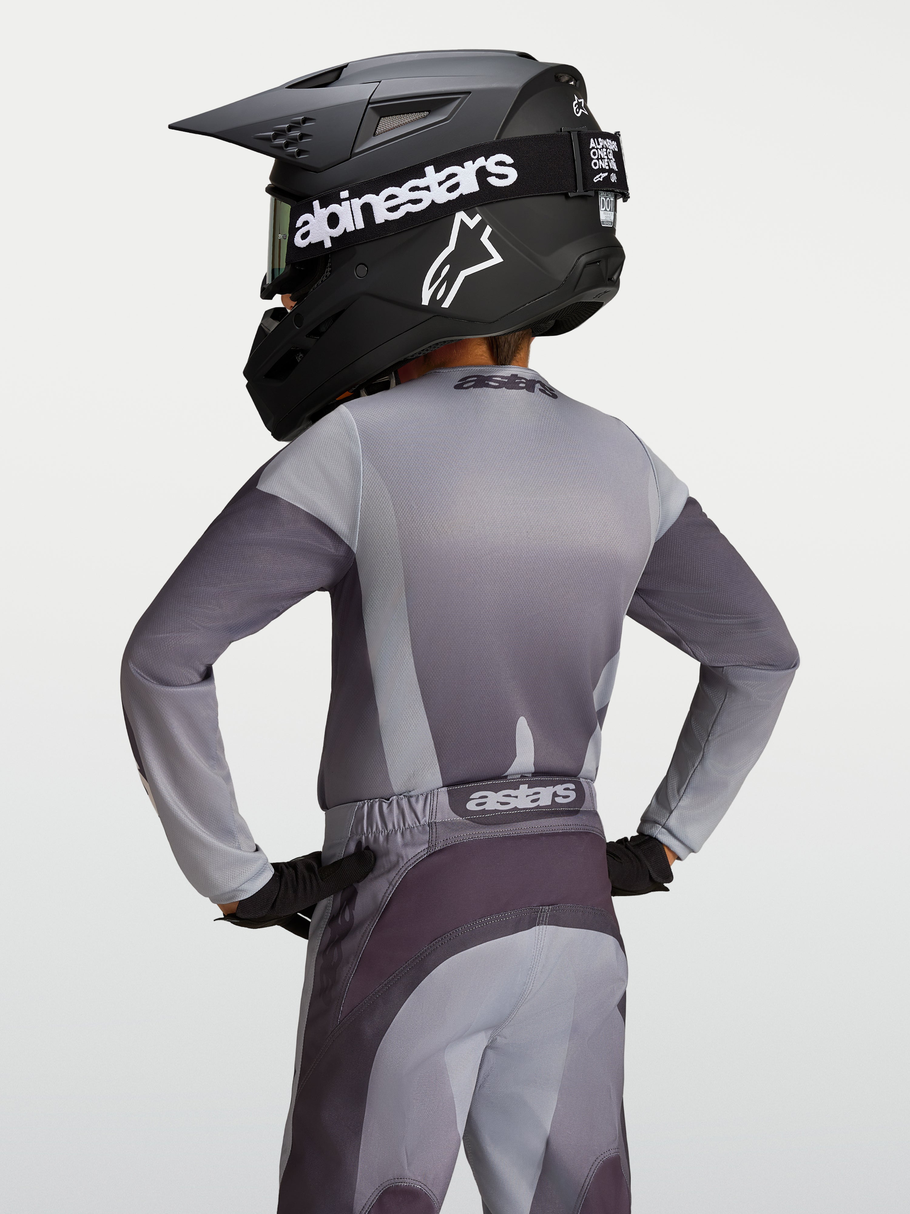 Alpinestars Jersey Fluid Amber Juvenil, jersey de motocross, gris y arena, transpirable, vista trasera de joven piloto