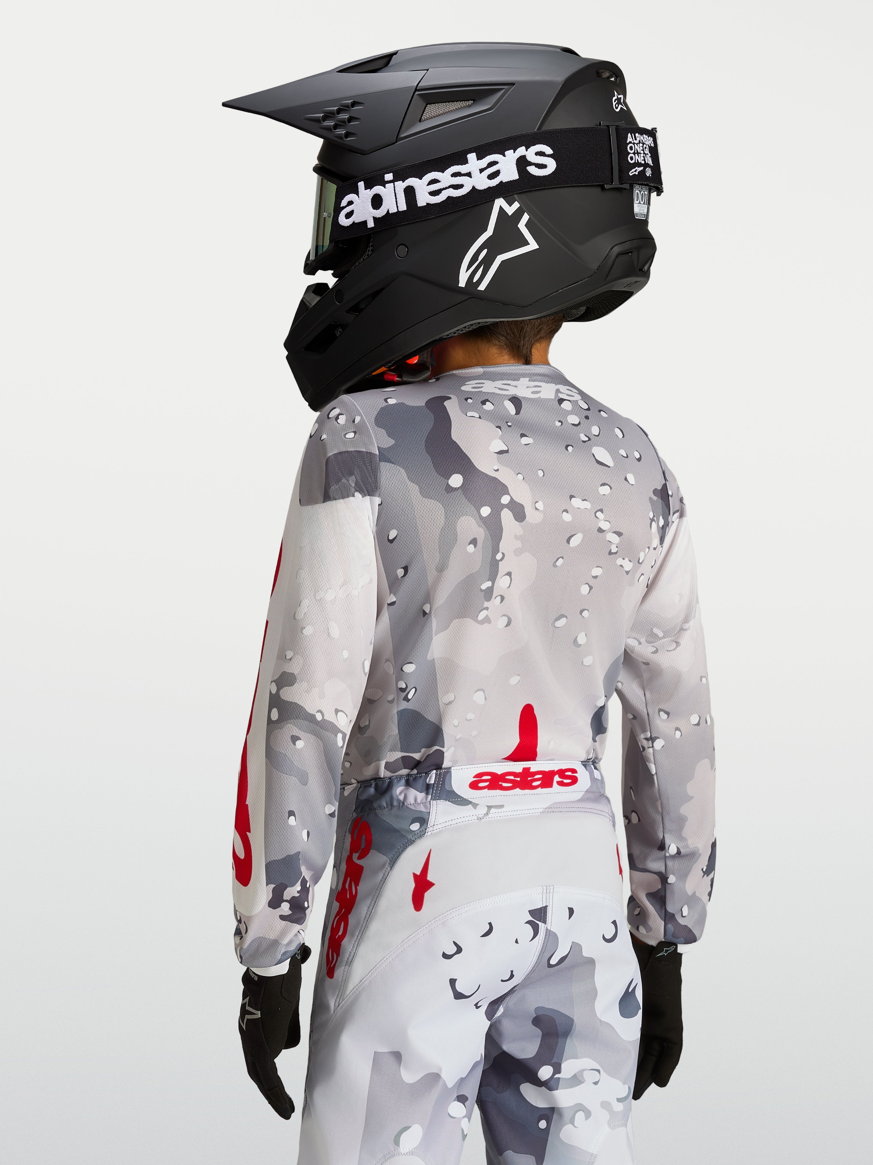 Alpinestars Jersey Fluid Lone Juvenil, jersey de motocross gris y rojo, vista posterior con ajuste ergonómico.