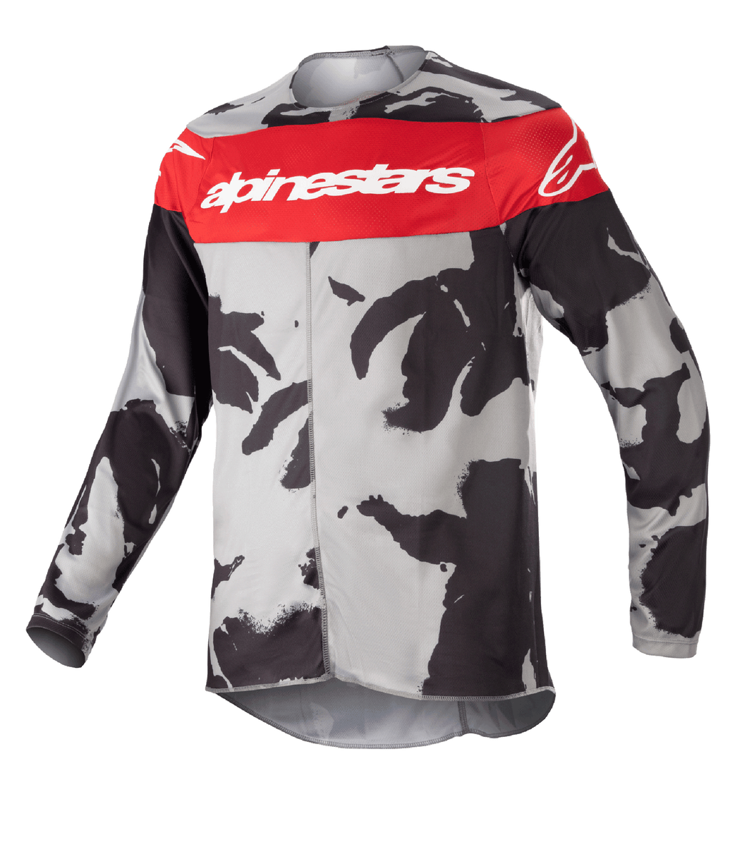 Alpinestars Youth 2023 Racer Tactical Jersey, jersey de motocross, camuflaje Gris Cast y Rojo Mars, con una banda roja horizontal en el pecho y el logotipo blanco de Alpinestars, patrón de camuflaje gris y negro, tejido ligero que absorbe la humedad para conducción off-road