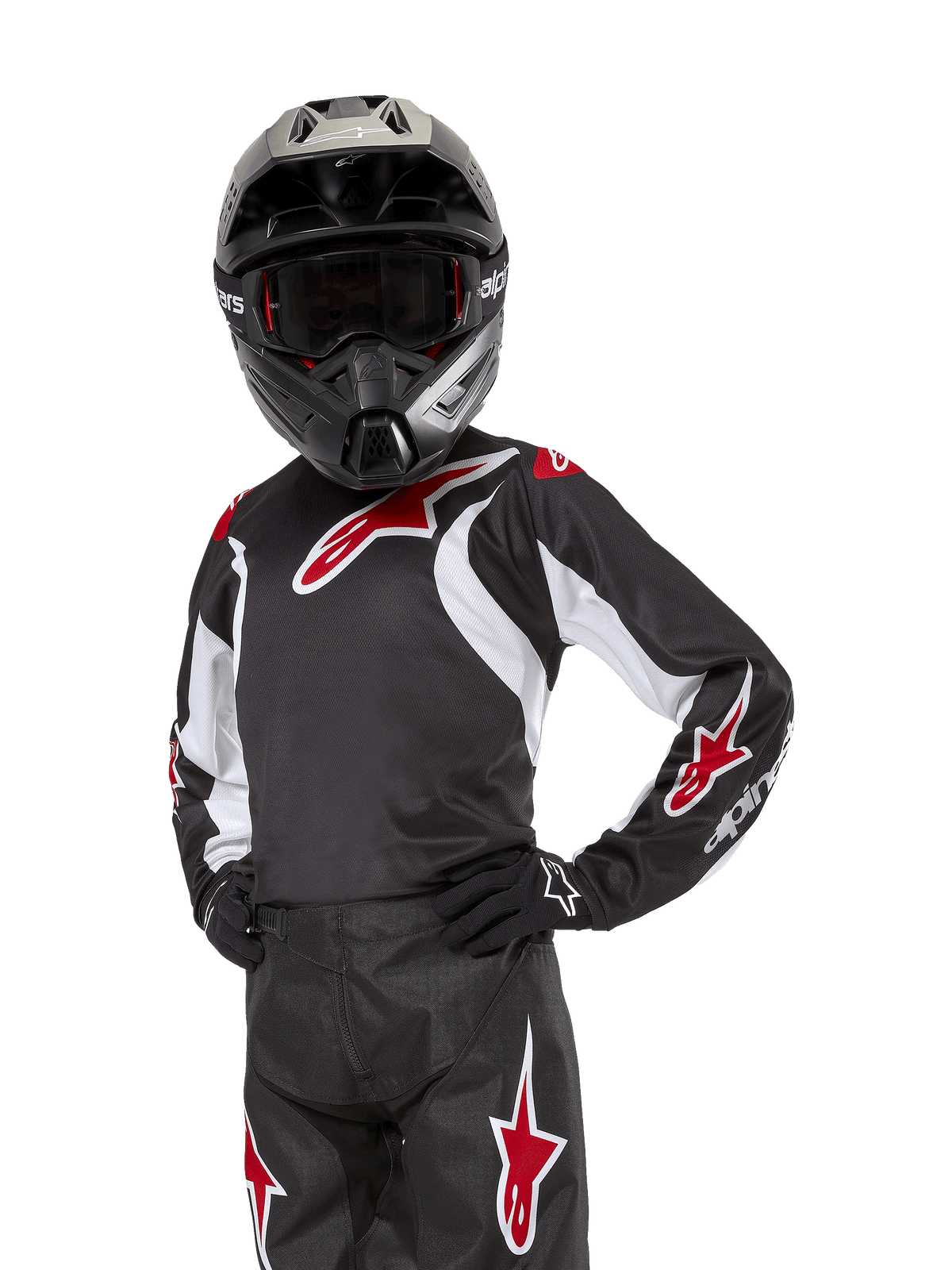 Alpinestars Youth 2024 Racer Lucent Jersey, jersey de motocross juvenil, negro, blanco y rojo, usado por un joven piloto con casco negro y pantalones a juego, con logotipos de estrellas rojas y detalles gráficos blancos, equipamiento off-road de alto rendimiento para carreras de motocross