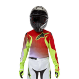 Alpinestars Jersey Racer Lucent Juvenil 2024, jersey de motocross, blanco, rojo neón y amarillo flúor, con un diseño en rojo y amarillo neón con el logotipo de la estrella en negro, usado con casco negro a juego, pantalones blancos y guantes neón para un equipo profesional de carreras todoterreno.