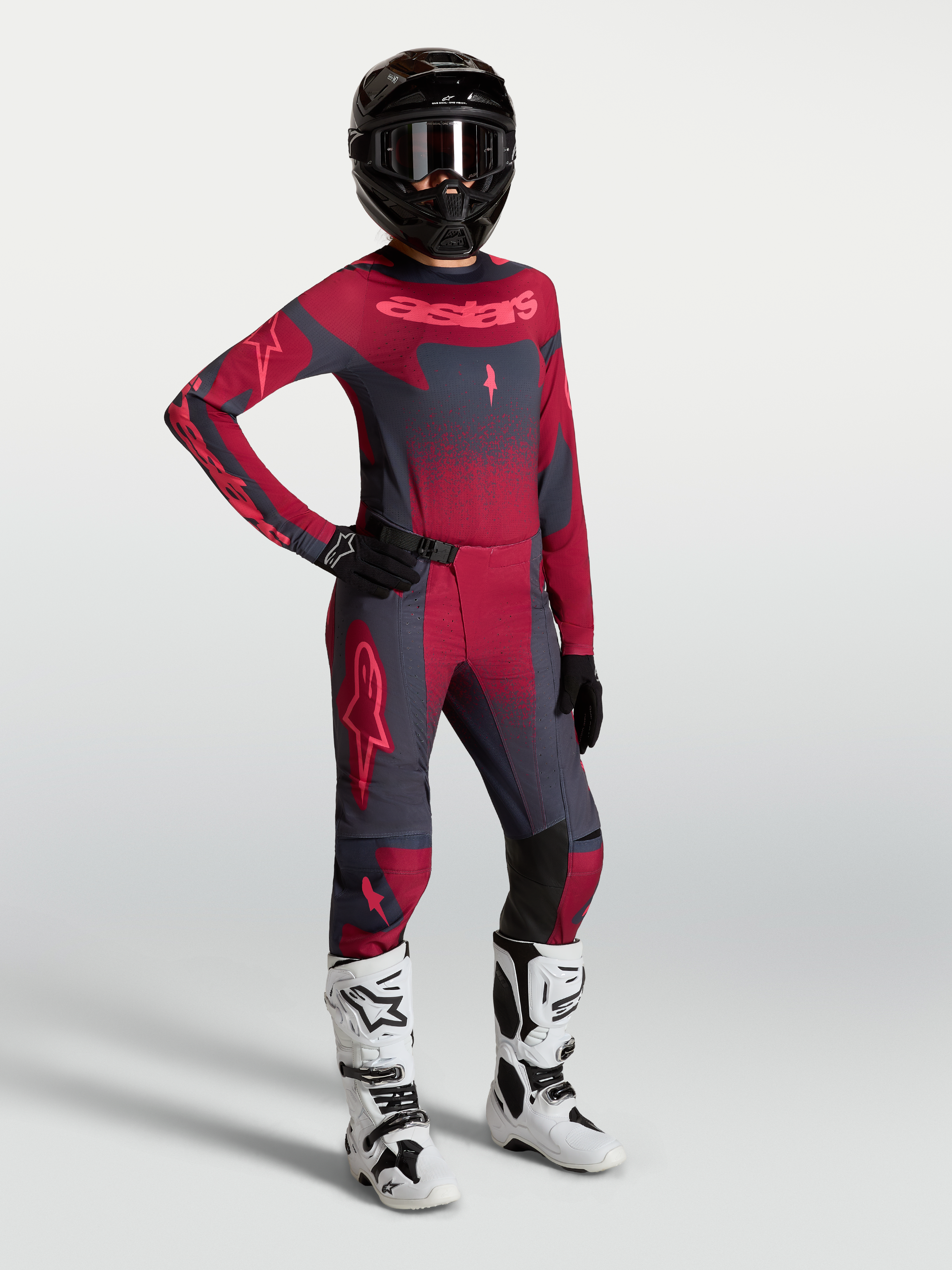 Alpinestars Stella Techstar Swan, equipación de motocross para mujer en carmesí y gris oscuro con botas blancas.