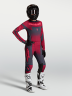 Alpinestars Stella Techstar Swan Jersey y Stella Techstar Swan Gear Set, conjunto de motocross para mujer, rojo y gris oscuro, con casco negro y botas blancas, diseño técnico para off-road.