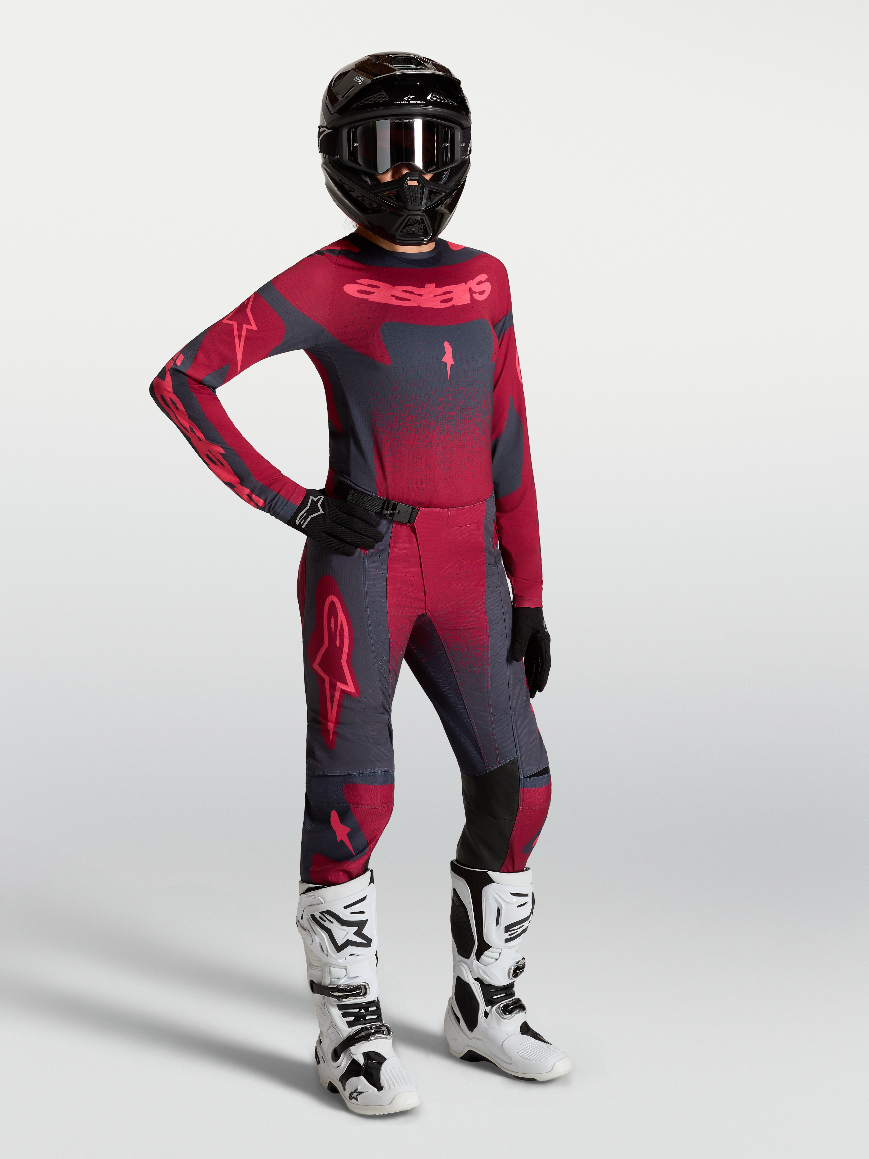 Alpinestars Stella Techstar Swan Jersey y Stella Techstar Swan Gear Set, conjunto de motocross para mujer, rojo y gris oscuro, con casco negro y botas blancas, diseño técnico para off-road.