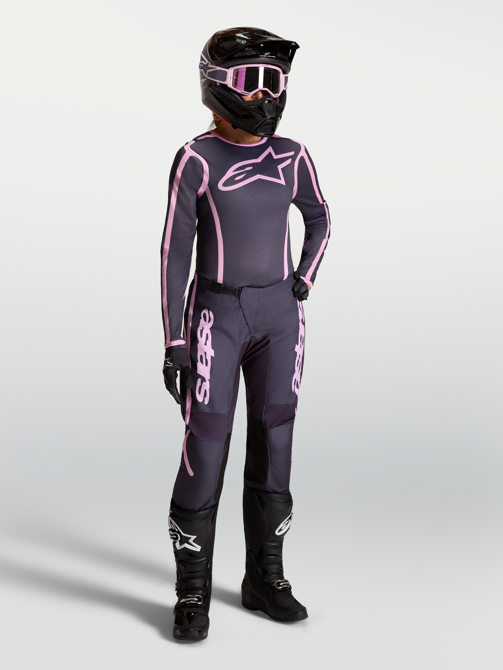 Alpinestars Stella Fluid Apex V2, jersey y conjunto de motocross para mujer, gris y rosa con botas de carreras negras.