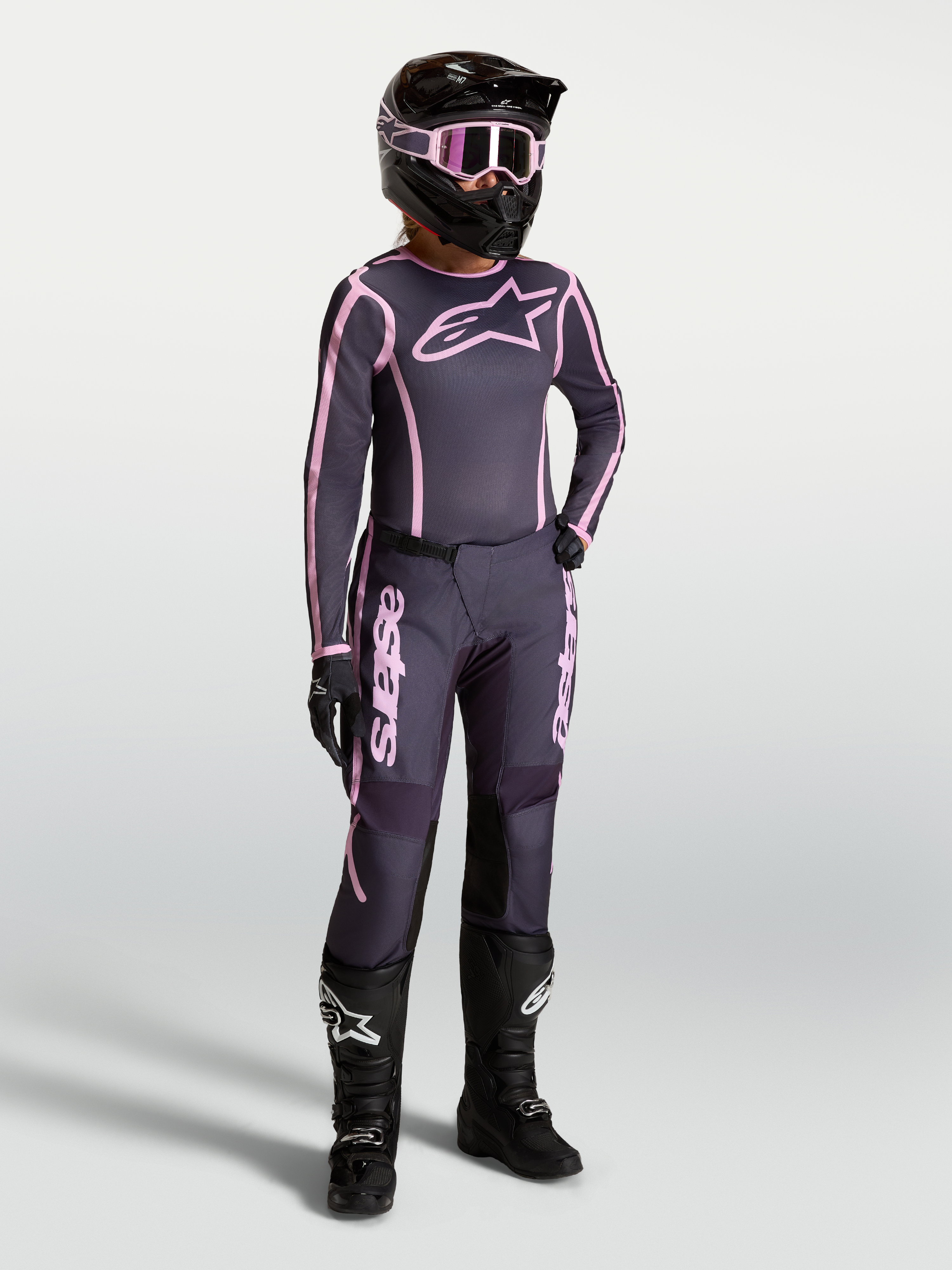 Alpinestars Stella Fluid Apex V2, jersey y conjunto de motocross para mujer, gris y rosa con botas de carreras negras.