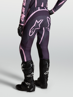 Alpinestars Stella Fluid Apex V2, pantalones de motocross para mujer en color gris y rosa, con botas Tech 7 negras.