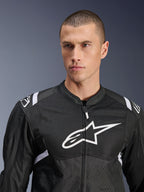 Chaqueta Alpinestars T-SPS Air V2, chaqueta de moto textil, negra y blanca, con un gran logotipo blanco en el pecho y paneles de malla, ajuste deportivo de alto rendimiento usada por un modelo masculino