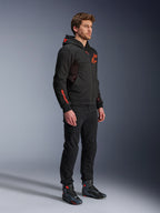 Alpinestars Chrome Air Sport Hoodie, Negro Rojo Flúor, sudadera de conducción urbana con forro polar técnico, combinada con pantalones negros y botas de moto, con paneles de ventilación de malla y logotipos en rojo flúor en el pecho y la manga