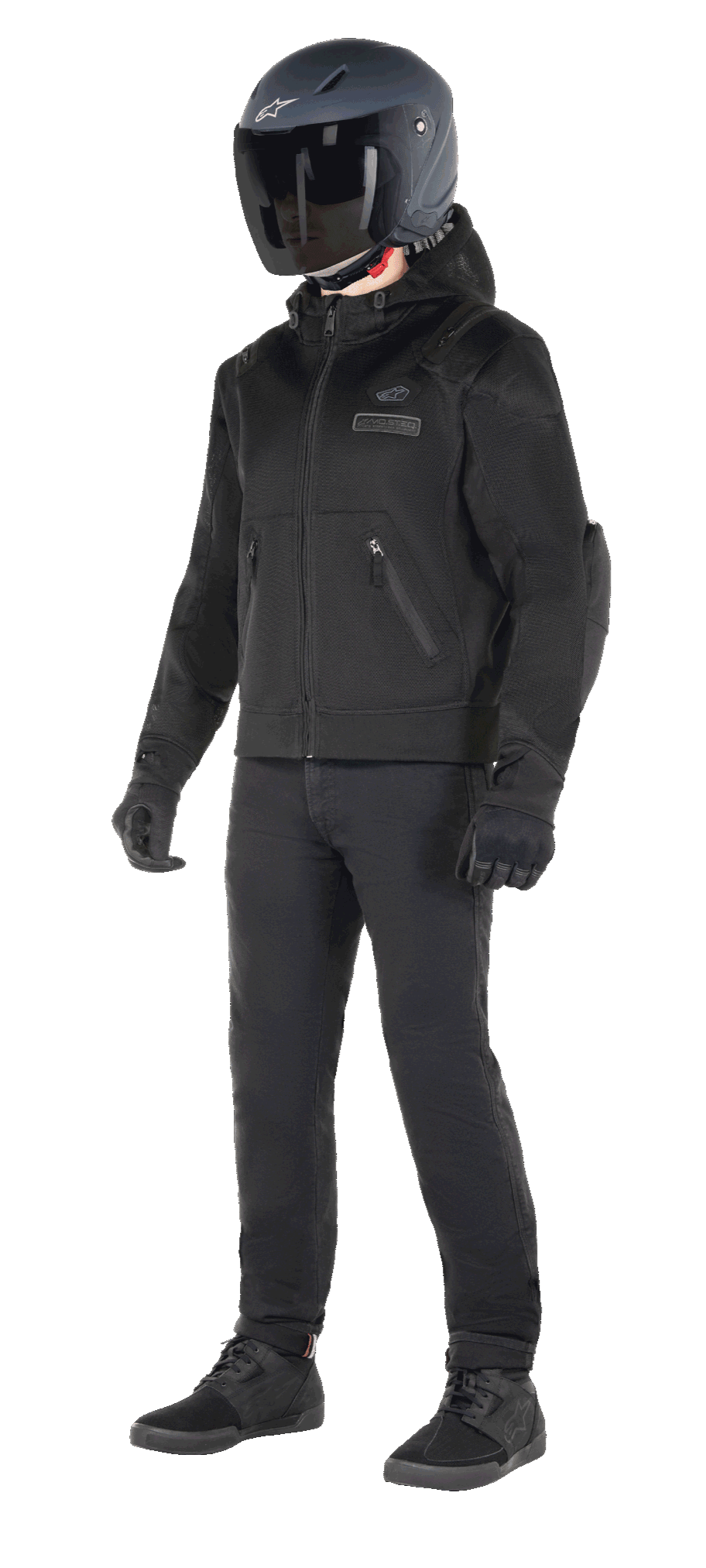 Sudadera con capucha Alpinestars Moflow Air Tech, sudadera urbana para moto, color negro, usada por un piloto con casco negro mate, guantes negros y pantalones de conducción, con una confección íntegra en malla para el flujo de aire, bolsillos con cremallera y logotipos sutiles en el pecho, diseño casual y elegante para conducción urbana en climas cálidos.