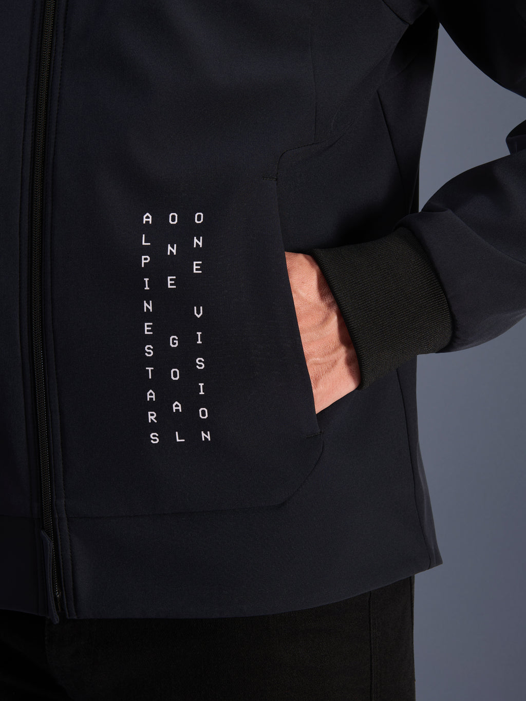 Alpinestars Radium Tech Hoodie, black urban motorcycle jacket with white vertical text graphic and ribbed windproof cuff.