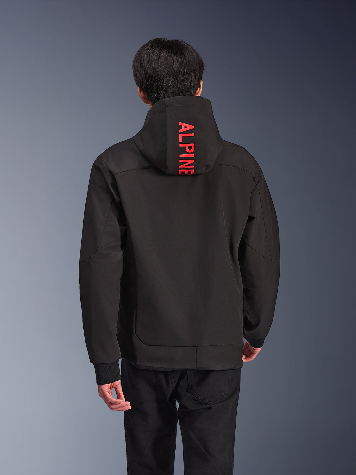 Sudadera con capucha Alpinestars Radium Tech, chaqueta de moto urbana, negra con logotipos en rojo brillante, vista trasera con el texto vertical 'ALPINE' en la capucha, carcasa técnica de 3 capas con puños acanalados, diseño atlético moderno