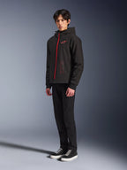 Alpinestars Radium Tech Hoodie, Black Bright Red, sudadera técnica para conducción urbana con cremallera frontal roja y logotipo en el pecho, vestida por un modelo con pantalones negros y zapatillas negras con suelas blancas, toma de estudio de cuerpo completo.