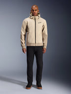 Alpinestars Radium Tech Hoodie en Mastic Aluminum, sudadera urbana para motociclista usada por un modelo masculino con pantalones y botas negras, con cremallera negra completa, logotipo pequeño en el pecho y ajuste atlético para conducción en ciudad.
