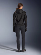 Alpinestars Stella Chrome Superairflow Hoodie, sudadera técnica de moto para mujer, malla 3D negra con pequeño logotipo naranja en el hombro, vista trasera, combinada con pantalones de conducción negros, guantes y botas negros, diseñada para conducción urbana deportiva