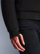 Primer plano de la sudadera Alpinestars Stella Chrome Superairflow negra, con tejido técnico de malla 3D y puño elástico acanalado con orificio integrado para el pulgar para un ajuste seguro.