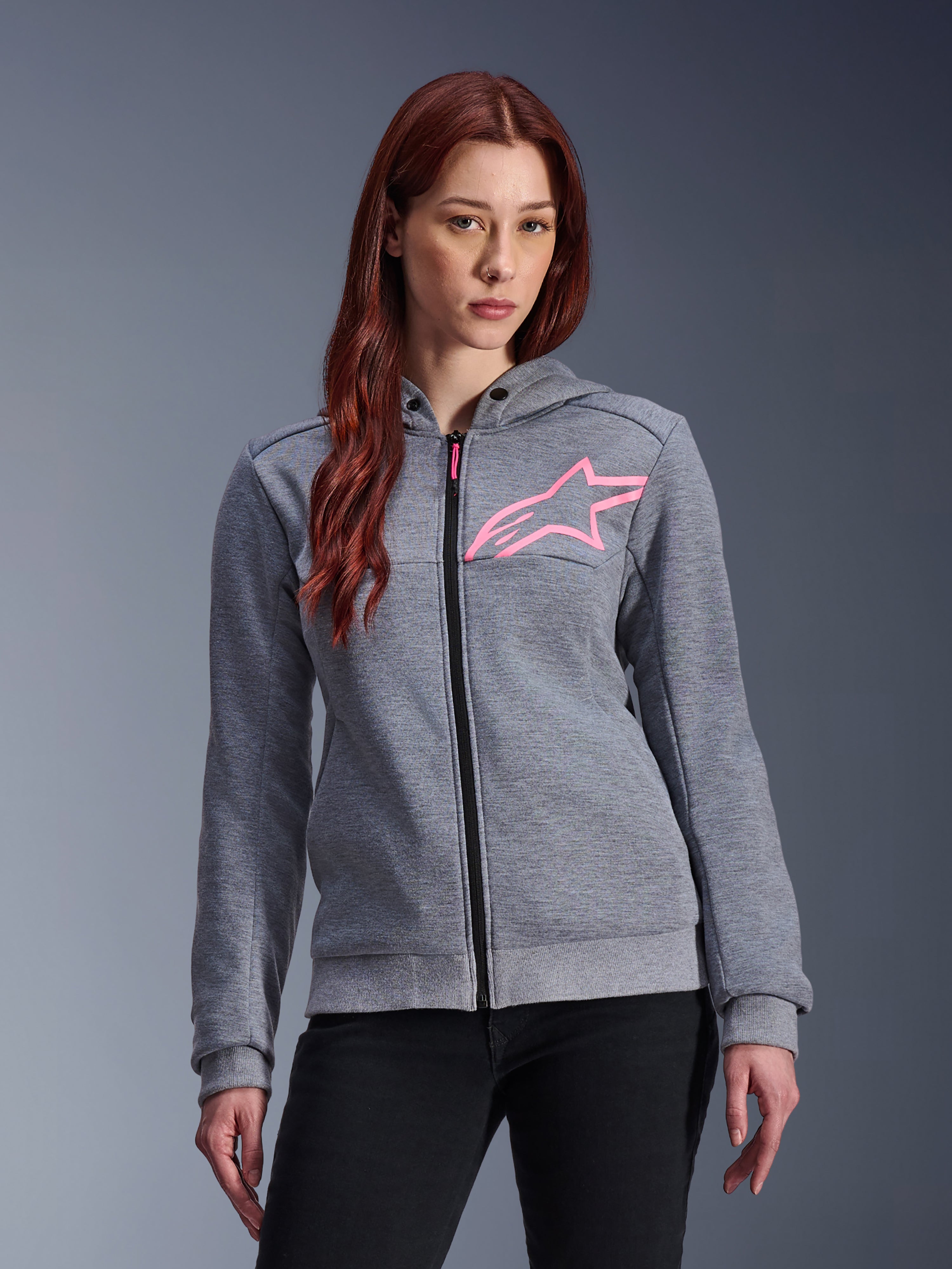 Alpinestars Stella Chrome V2 Sport Hoodie, sudadera de moto para mujer, gris jaspeado con logo de estrella en rosa flúor, tejido técnico de forro polar con puños y dobladillo acanalados, cremallera frontal negra con tirador rosa, ropa urbana casual de estilo streetwear combinada con pantalones negros
