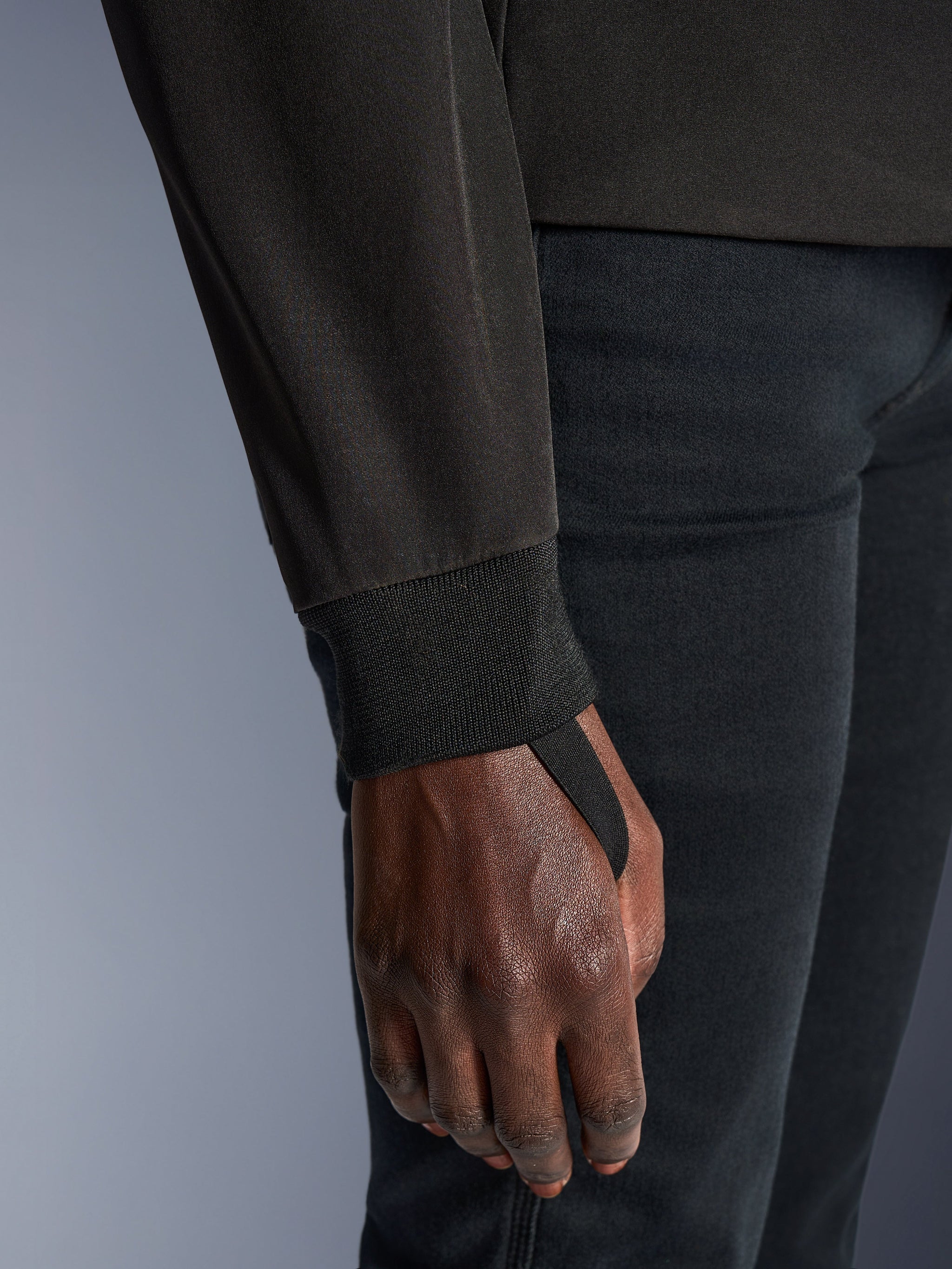 Close-up of Alpinestars Woman Stella Radium Tech Hoodie in Deep Gray Black, highlighting the ribbed stretch cuff and thumb loop for wind sealing and secure fit during urban riding.