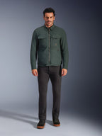 Sobrecamisa Alpinestars Bryon WR, chaqueta de moto resistente al agua, esmeralda oscuro, combinada con pantalones negros y botas negras, con confección en lona encerada, bolsillos cargo en el pecho y un diseño urbano moderno