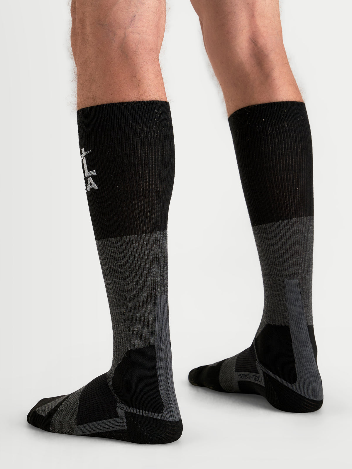 Alpinestars AT-8 Merino Calcetines, calcetines de moto para aventura, grises y negros, térmicos de rendimiento sobre la pantorrilla con acolchado reforzado, vista trasera en modelo