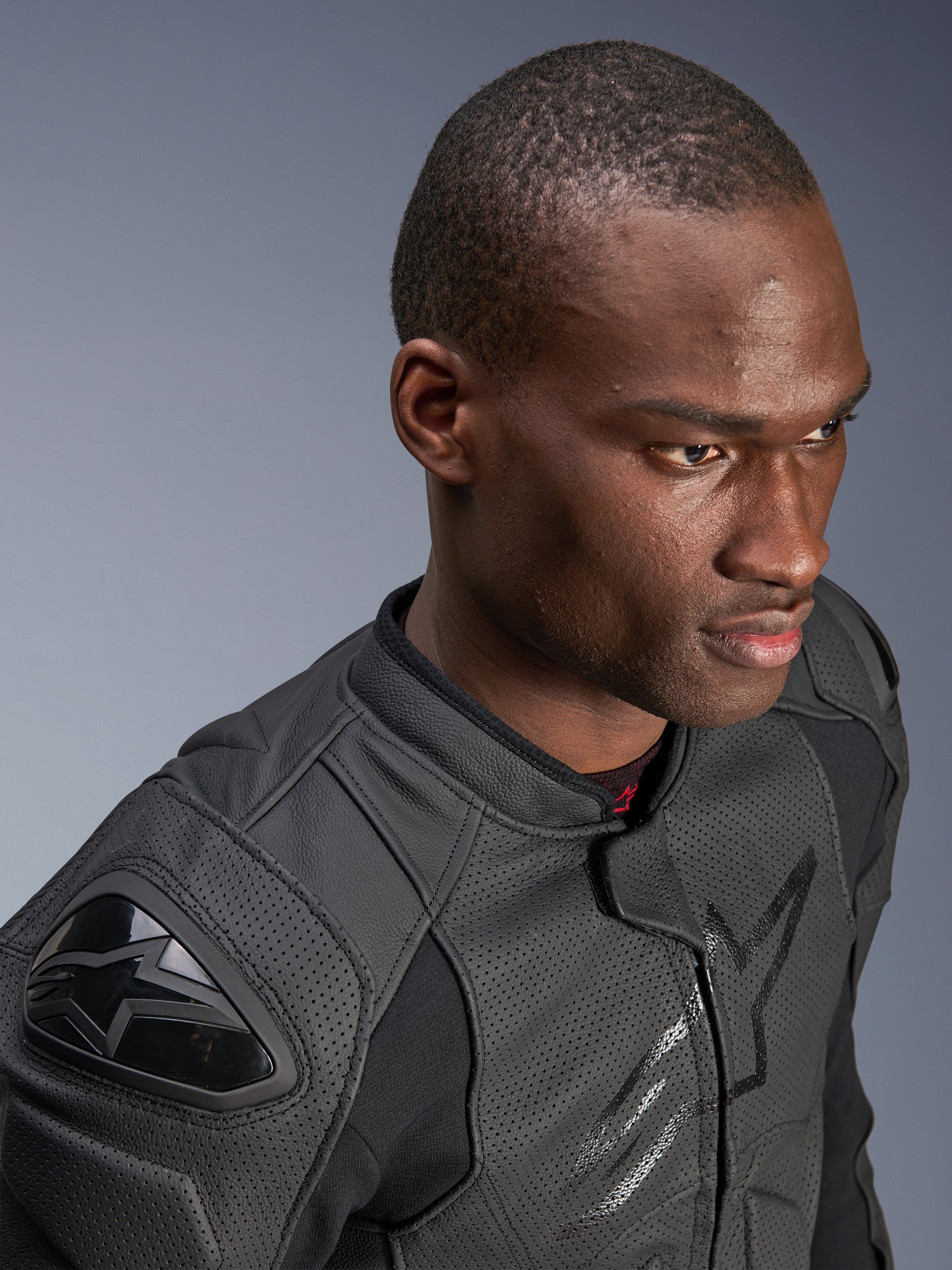 Primer plano de un modelo con la chaqueta de cuero Alpinestars Dusk Airflow, color Black on Black, con amplias zonas de cuero perforado para transpirabilidad, deslizadores de hombro externos DFS y un diseño moderno para conducción deportiva.