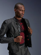 Chaqueta de cuero Alpinestars Dusk Airflow, color Black Black, usada por un modelo masculino sobre una prenda técnica base roja y negra, con paneles de cuero perforado, deslizadores externos DFS en los hombros y un ajuste deportivo de alto rendimiento.