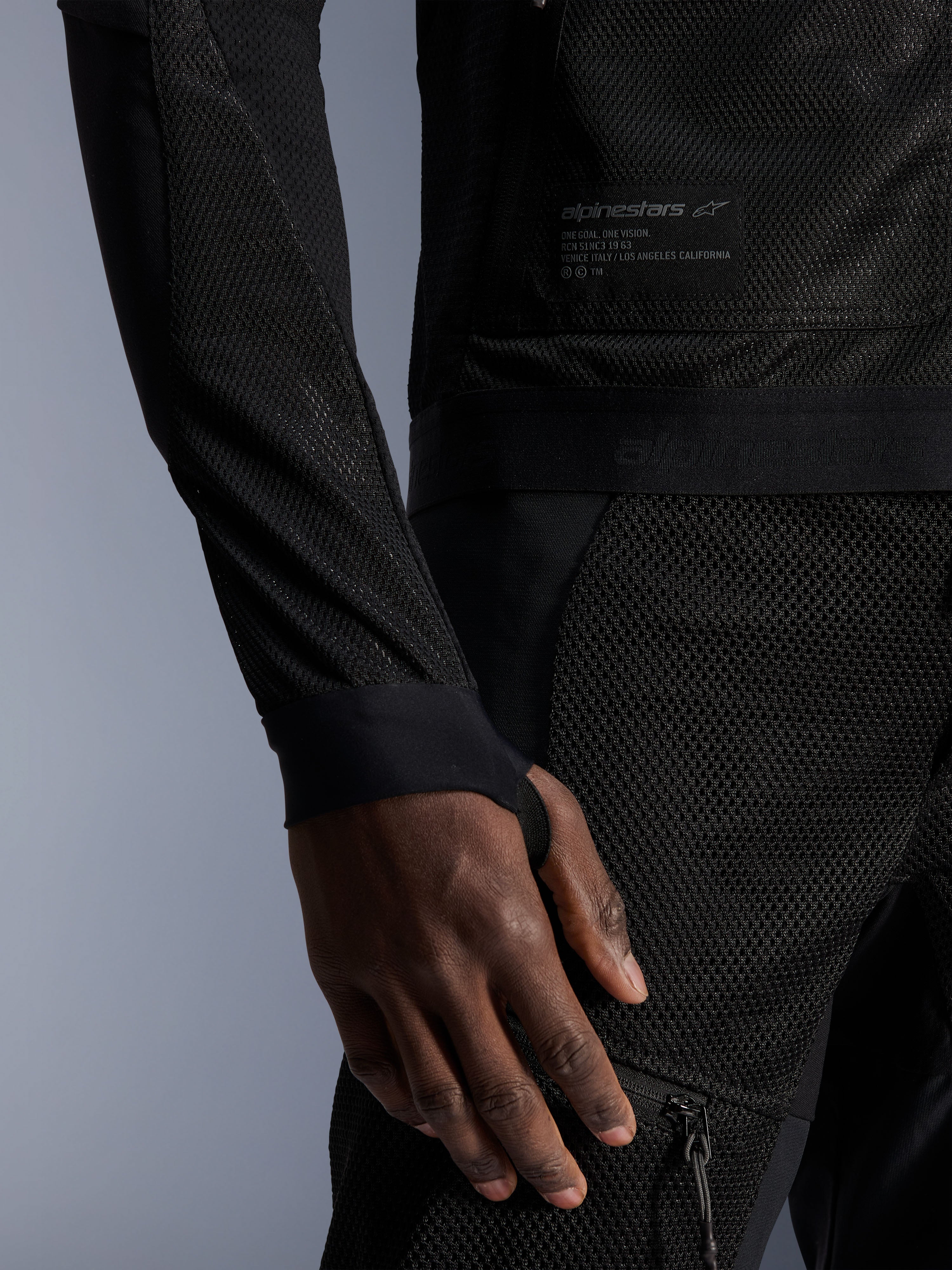 Chaqueta Alpinestars Troop-Air, negra, detalle de la construcción de malla técnica, parche de la marca con texto técnico y manga con orificio integrado para el pulgar, chaqueta de moto urbana de verano con diseño de alto flujo de aire