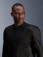 Chaqueta Alpinestars C-1 Air, negra, chaqueta de moto urbana con paneles de malla técnica, usada por un modelo, con un sutil logotipo de Alpinestars de transferencia de calor en el hombro, diseñada para el flujo de aire y comodidad ligera en climas cálidos