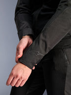 Alpinestars Stella C-1 Air Jacket, negra, primer plano del puño de la manga con un sutil logotipo de transferencia térmica, construcción ligera de tela y malla, ropa de moto urbana para mujer
