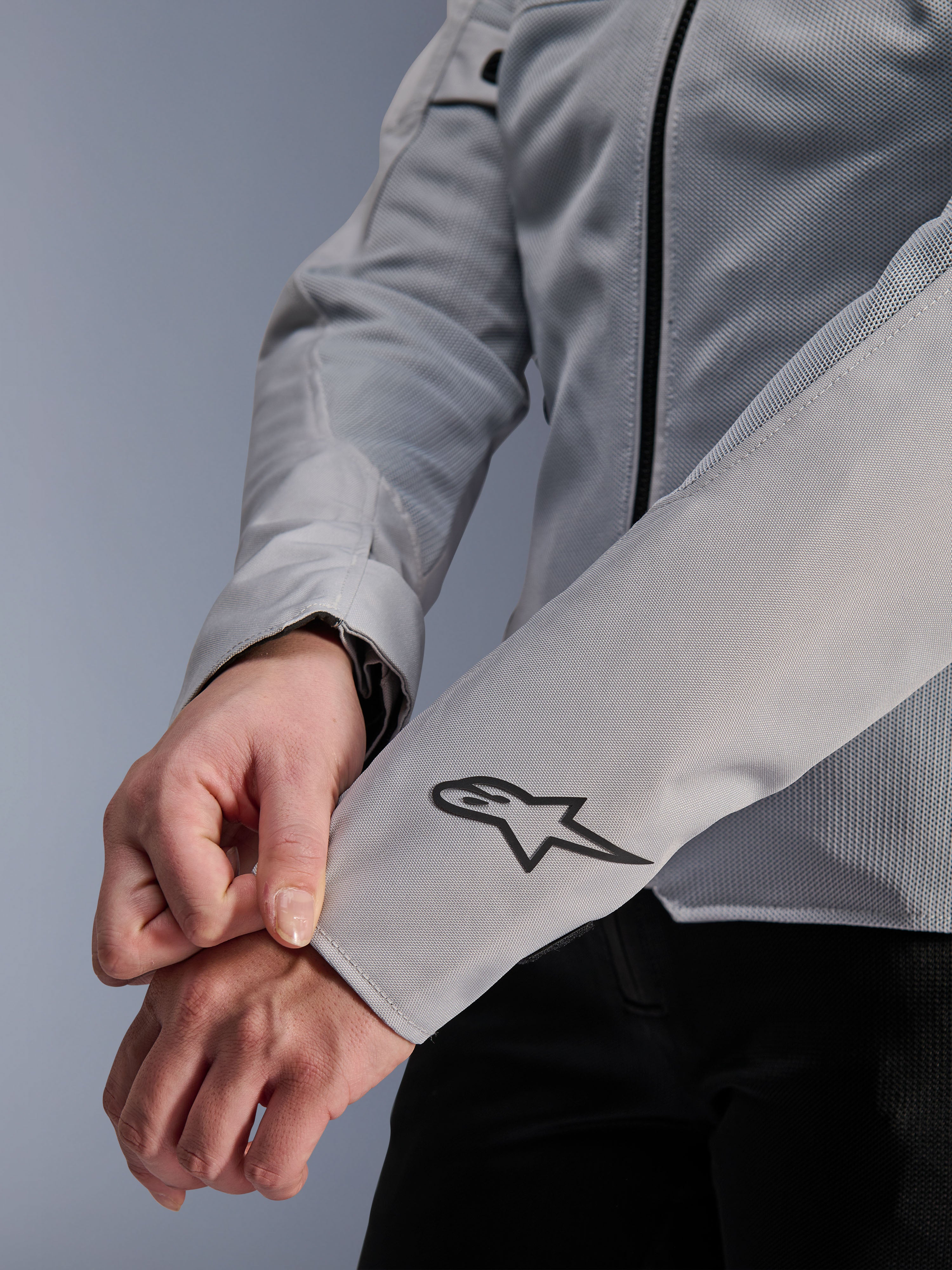Primer plano de la chaqueta Alpinestars Stella C-1 Air en color plata, con construcción de malla técnica y un logotipo negro de Alpinestars en la manga izquierda, chaqueta de moto urbana para mujer con marca reflectante.