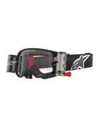 Alpinestars Supertech Corp Goggles Roll Off, Black frame with Clear lens, featuring a Wide Vision Roll-Off system and red pull tab, black strap with a large grey and white Alpinestars logo, technical motocross eyewear with "One Goal. One Vision." branding.