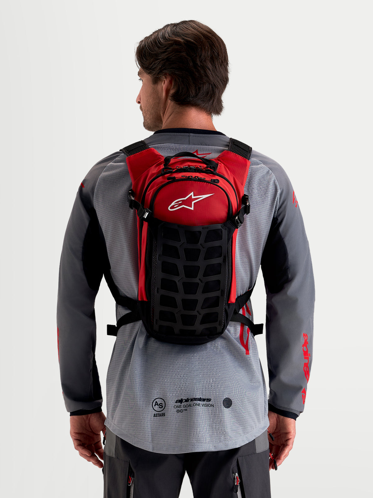Alpinestars AT-9 Backpack, motocross backpack, black and red, worn by a model from the back showing lightweight textile construction and padded harness system