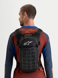Alpinestars Mochila AT-9, mochila de motocross compacta, negra con logotipo Alpinestars blanco, vista trasera en modelo