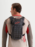 Alpinestars Mochila AT-9, mochila de motocross y uso diario, color gris oscuro y marrón, vista trasera en modelo