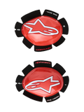 Deslizadores de rodilla Alpinestars GP Tech, rojos y blancos, protectores de rodilla para carreras de moto, con un gran logotipo de estrella blanca sobre plástico rojo brillante, texto 'ONE GOAL. ONE VISION.' en la base de velcro negro con forma de pétalo, par izquierdo y derecho para uso en pista