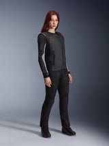 Alpinestars Stella Tech-Air 3 V2 System, chaleco airbag autónomo para moto de mujer en color negro, combinado con pantalones textiles de pilotaje y botas negras, con un ajuste entallado para protección urbana y de turismo